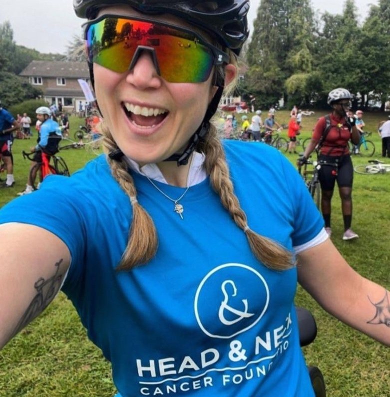 A cyclist wearing a HNCF branded t-shirt fundraising for the charity