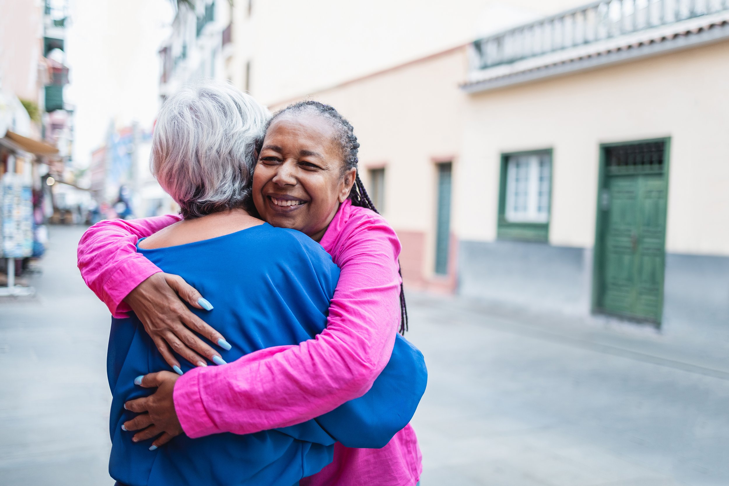 Two senior ladies hugging and offering each other comfort