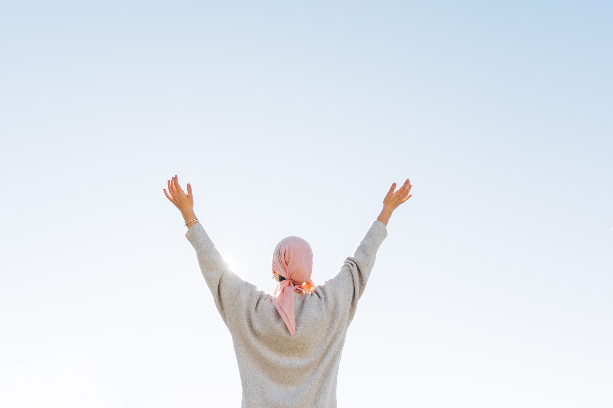 An oral cancer patient spreading her arms in relief