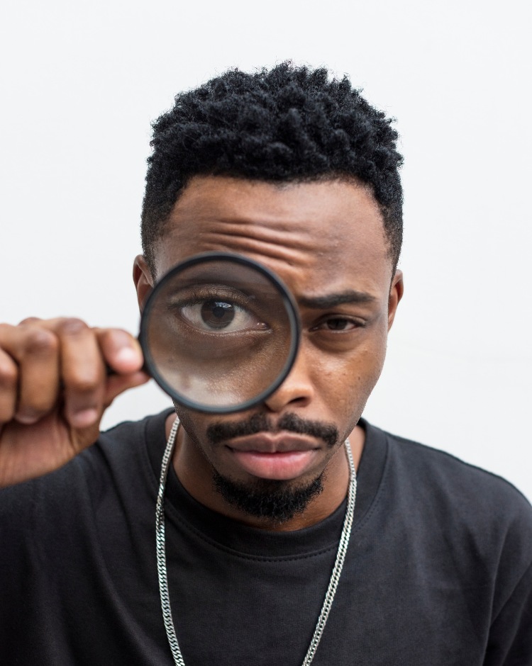 Man with magnifying glass examining for signs of cancer