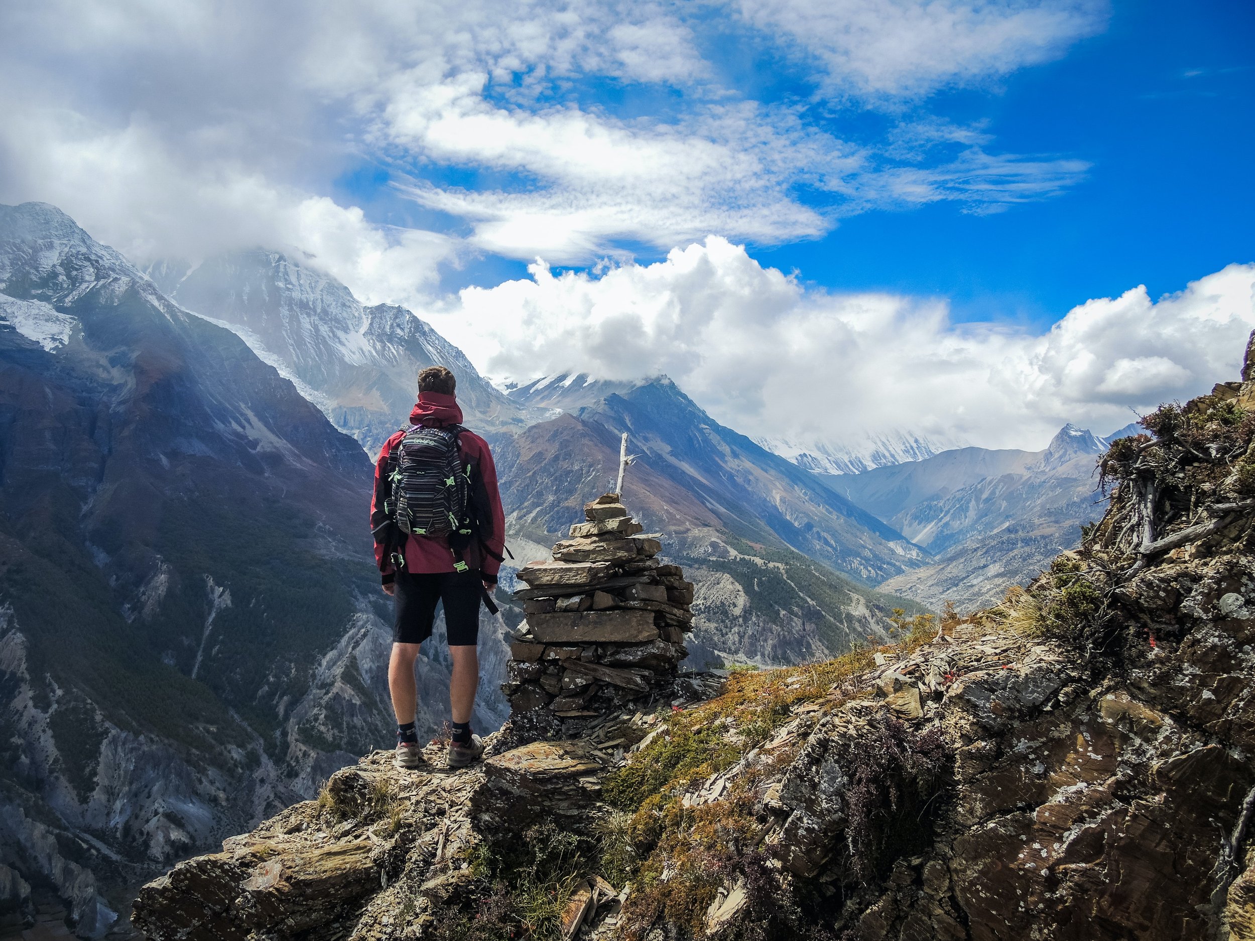 Man on top of a mountain after hiking to fundraise for charity